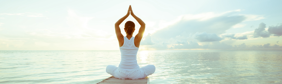 Femme pratiquant le Yoga au bord d'un lac.(Source: Adobe Stock)